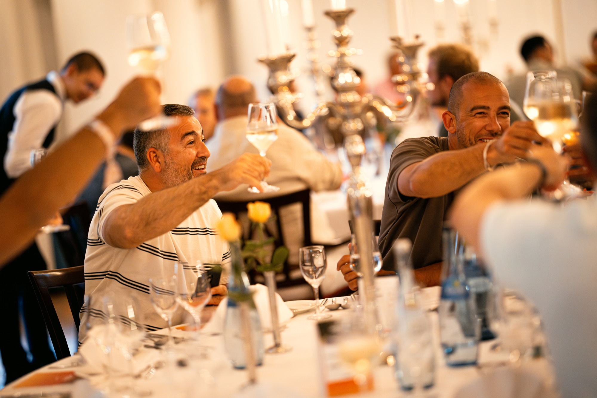 Members proosten aan de lange clubtafel tijdens een StreetGasm-avond.