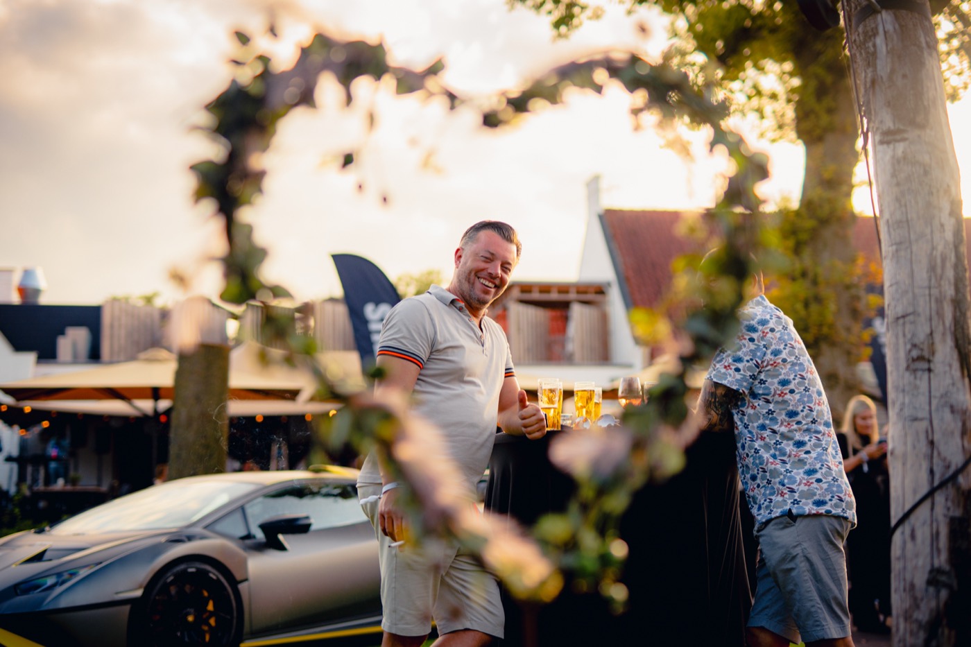 Supercars in tegenlicht bij zonsondergang tijdens een social.